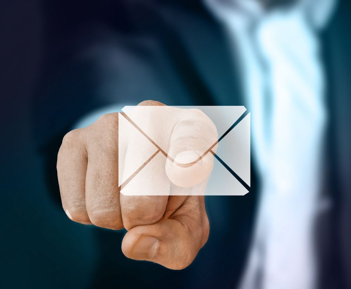 Persona con traje tocando con el dedo un icono de sobre de correo flotante