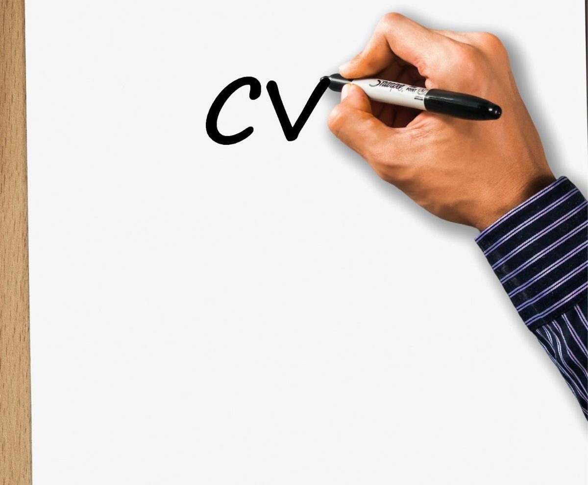 Persona escribiendo CV con un rotulador sobre fondo blanco