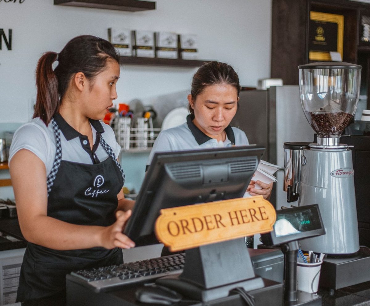 Dos camareras junto a un TPV en un mostrador de café