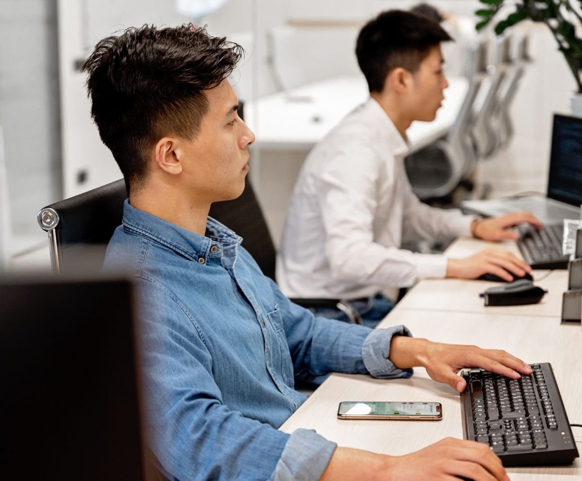Dos personas trabajando con ordenadores en una oficina