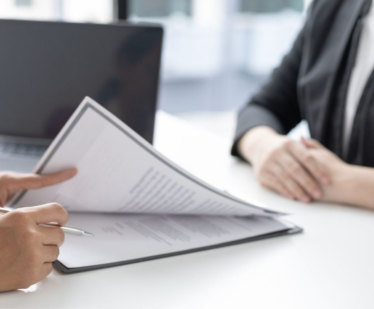 Persona revisando un documento sobre una mesa durante una reunión