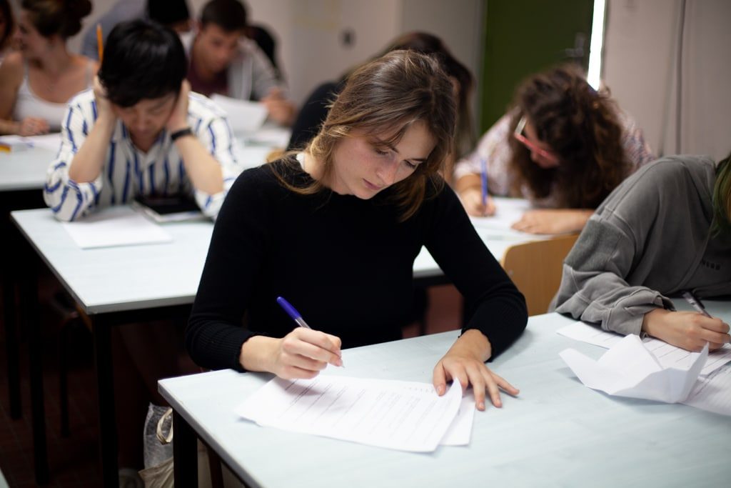 Personas realizando un examen escrito en un aula