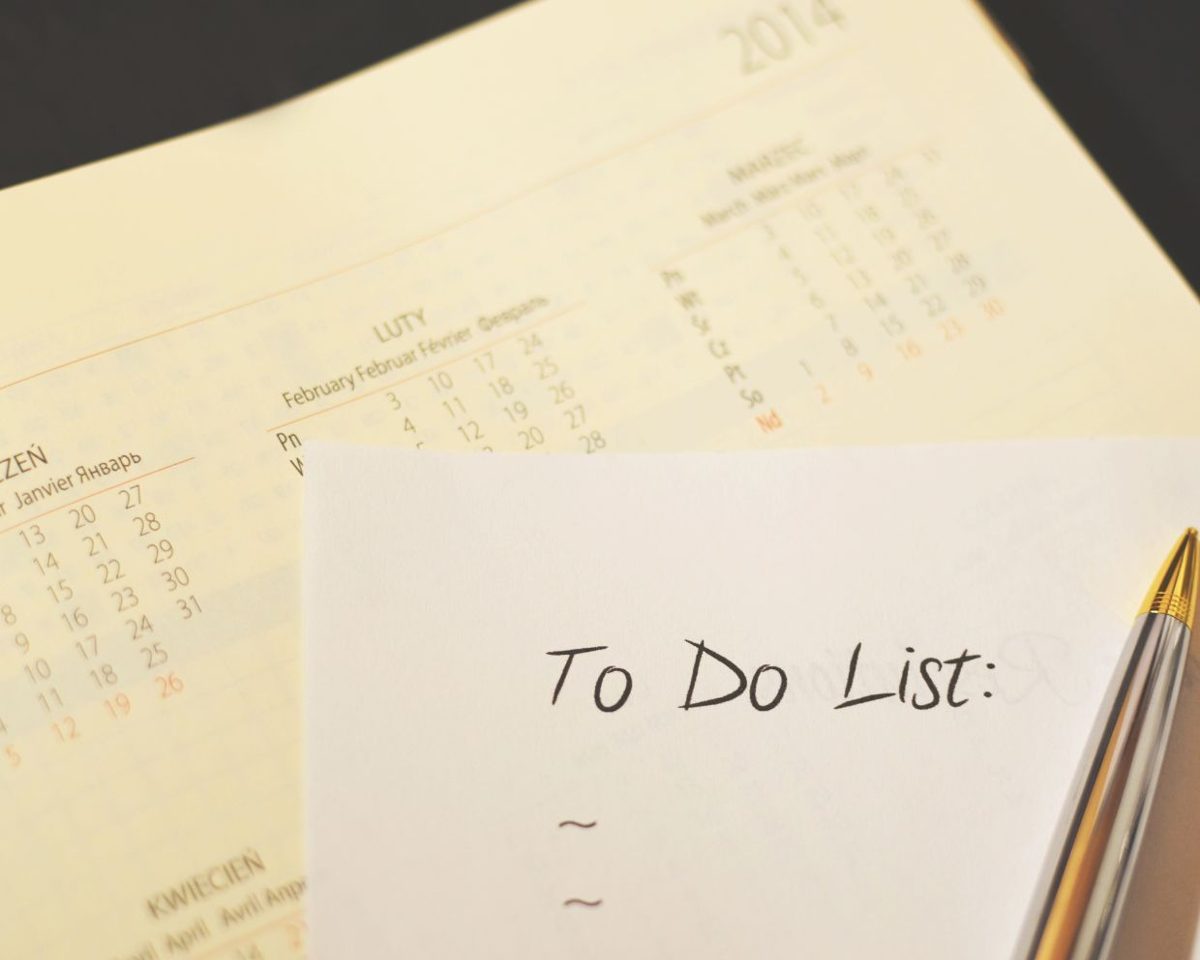 Nota adhesiva con el texto To Do List sobre un fondo beige junto a una lista de tareas