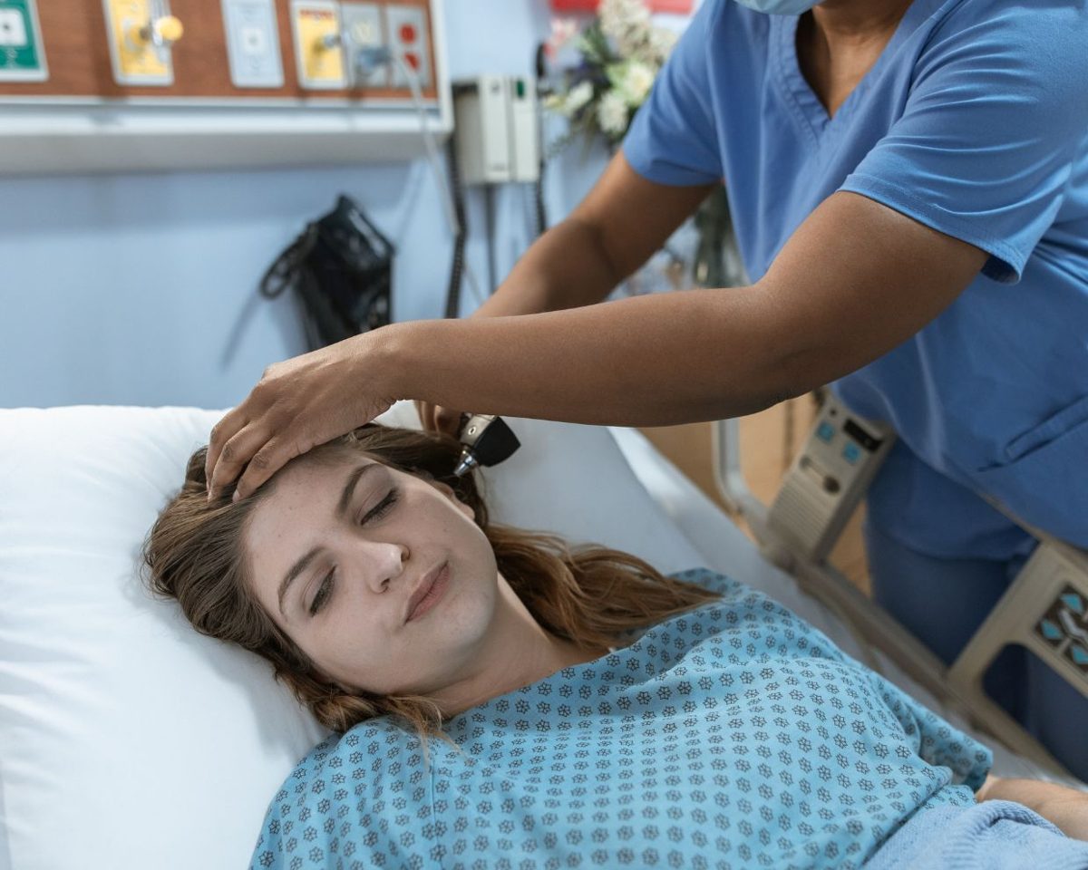 Profesionales sanitarios atendiendo a una paciente tumbada en una cama de hospital