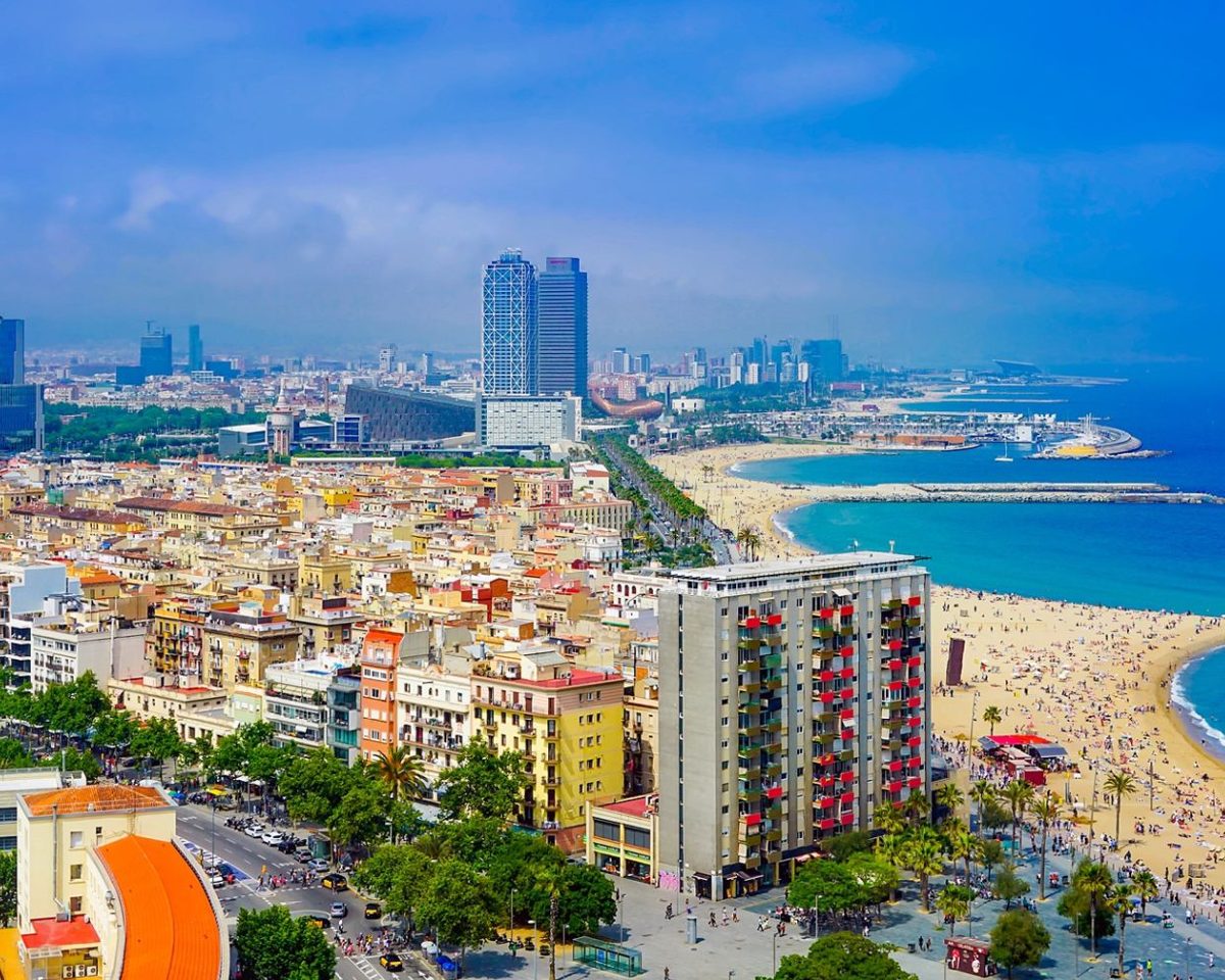 Vista de una ciudad costera con edificios altos junto a una playa de arena
